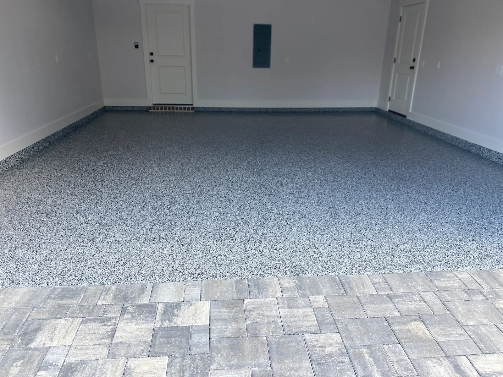 Finished garage floor coating and paver transition by Shoreline Coatings